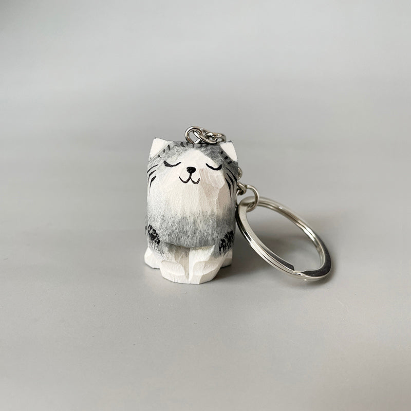 Close-up of a cute wooden cat keychain with a key ring