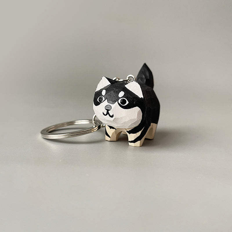 Side view of a hand-carved adorable dog keychain, showcasing the detailed paint job and key ring attachment