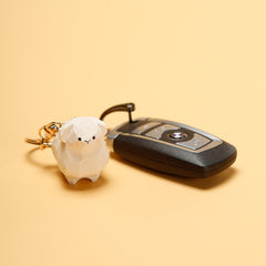 Cute wooden sheep keychain next to a car key