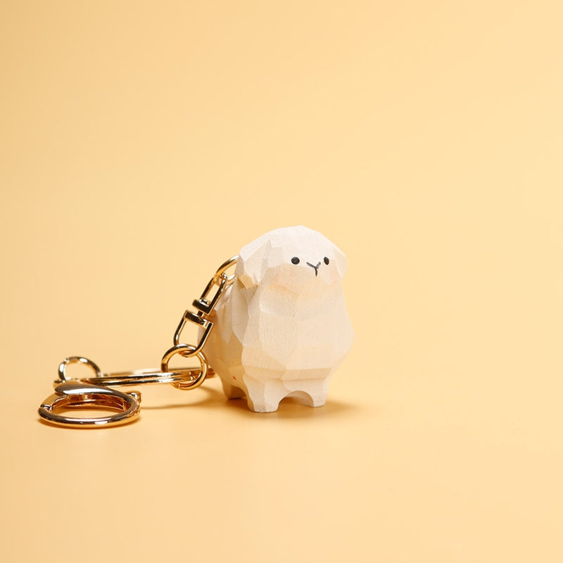 Hand-carved adorable sheep keychain on a yellow background