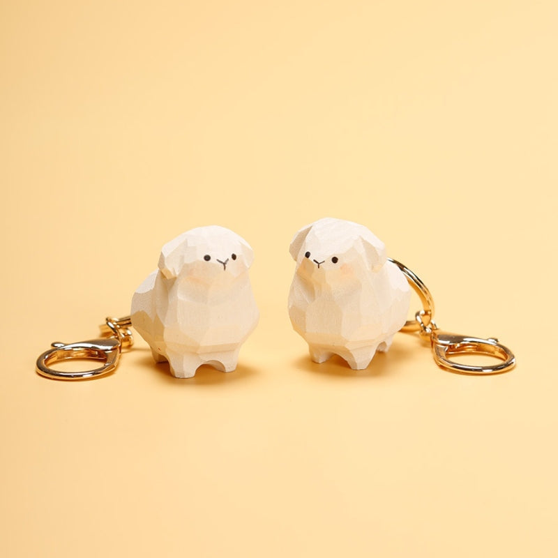 Two handmade wooden sheep keychains with gold rings