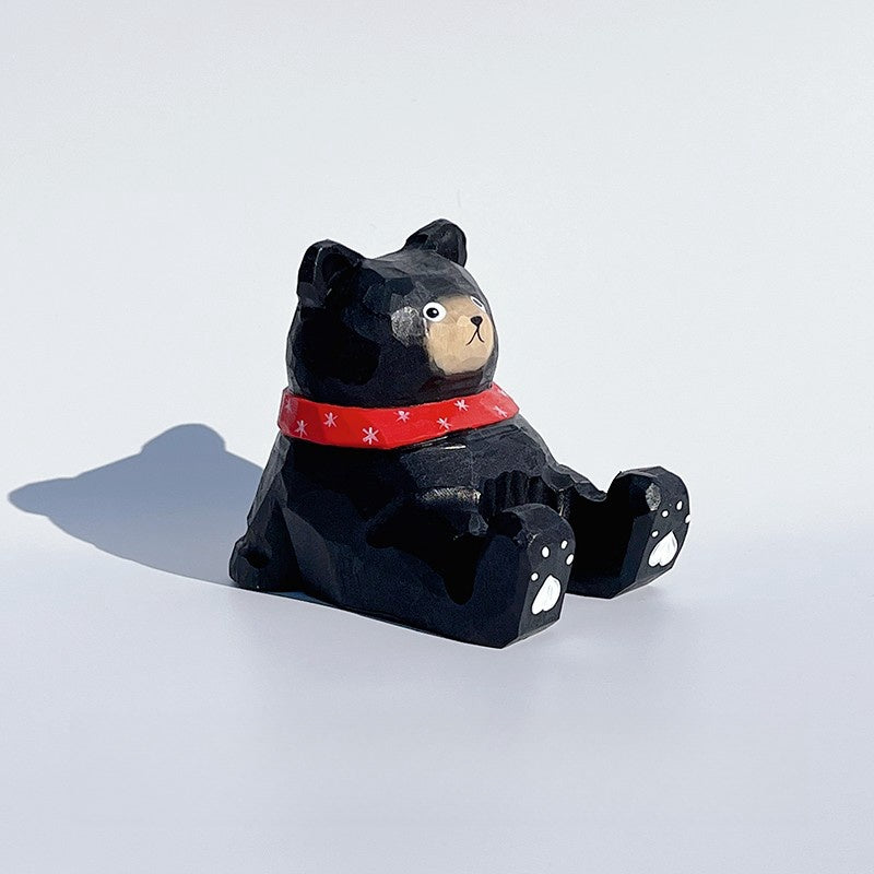 Black bear phone holder with cartoon style carved wooden figure.