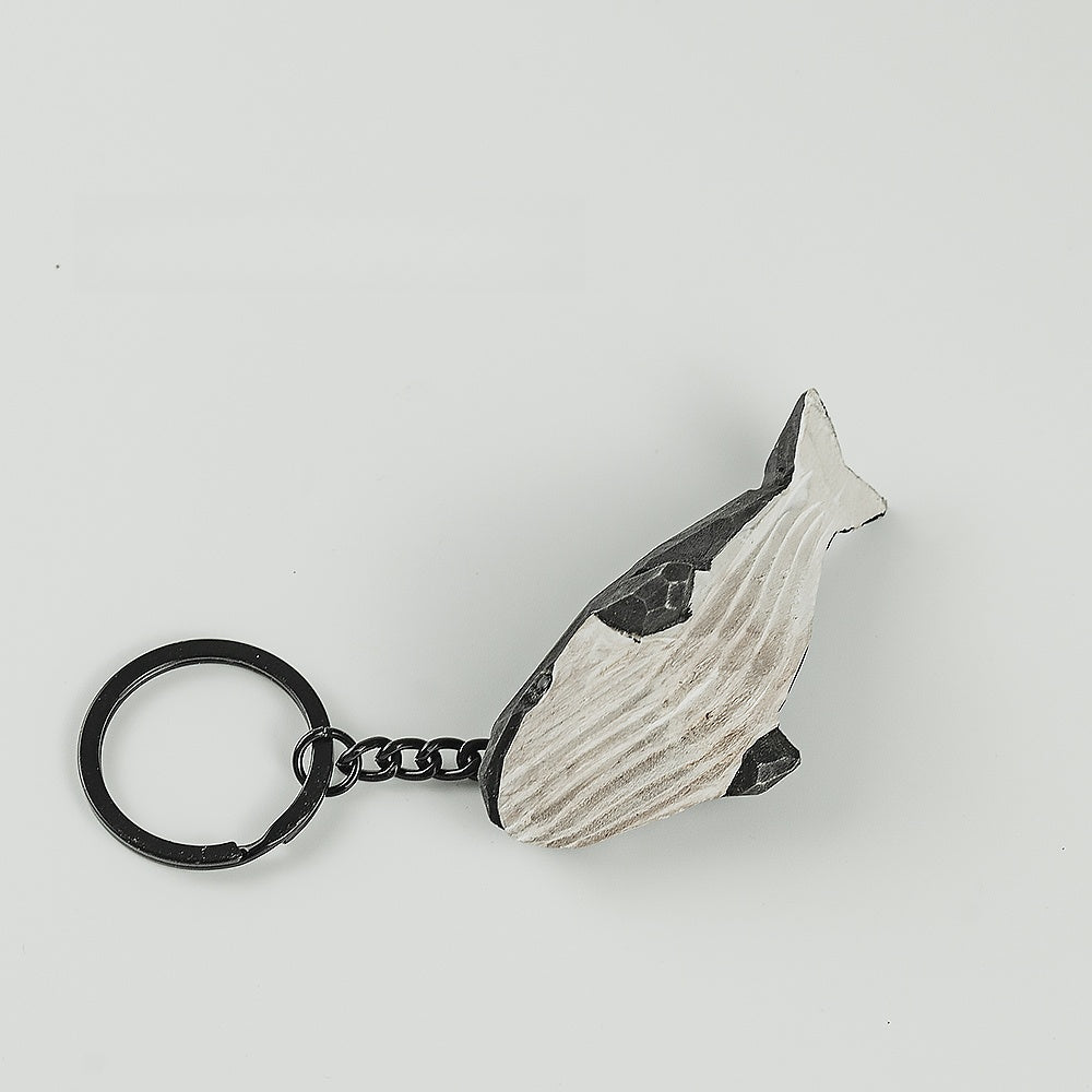 Top view of a black whale keychain, showcasing its engraved belly.