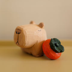 Capybara Figure with small wooden persimmon statue placed next to it.