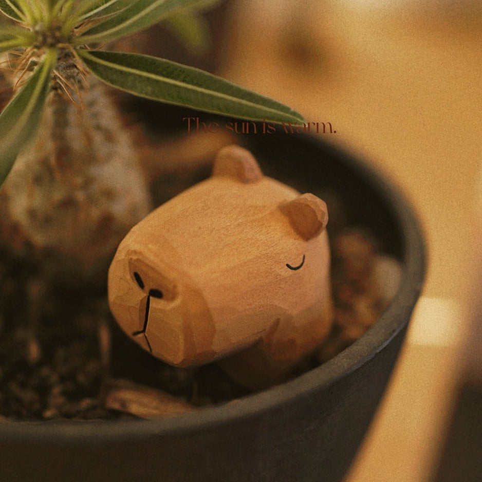 The Capybara figurine is placed in a flower pot as a decorative object.