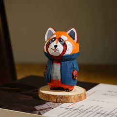 Unique hand-carved red panda in a cartoonish design, painted in bold orange and black with a playful blue jacket.