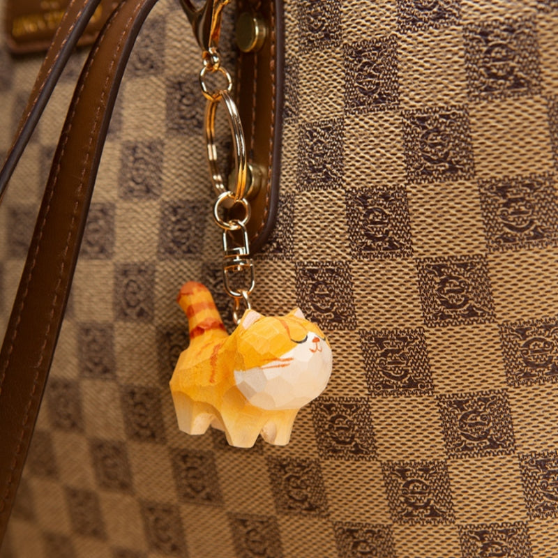 Chubby Orange Cat Keychain attached to a checkered handbag, adding charm and style.