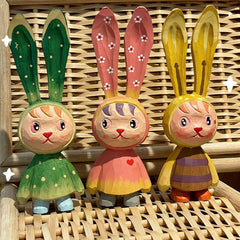 Colorful easter bunny figurines, hand-painted wooden statues.