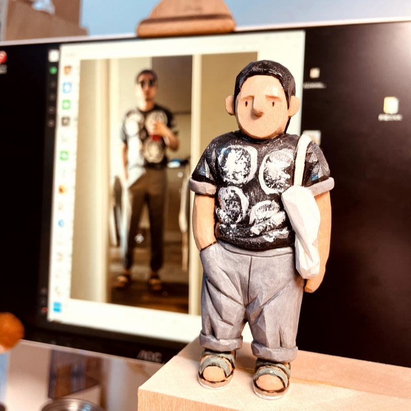 Custom figurine of a young man in a black graphic t-shirt and gray pants, hand-carved from wood.