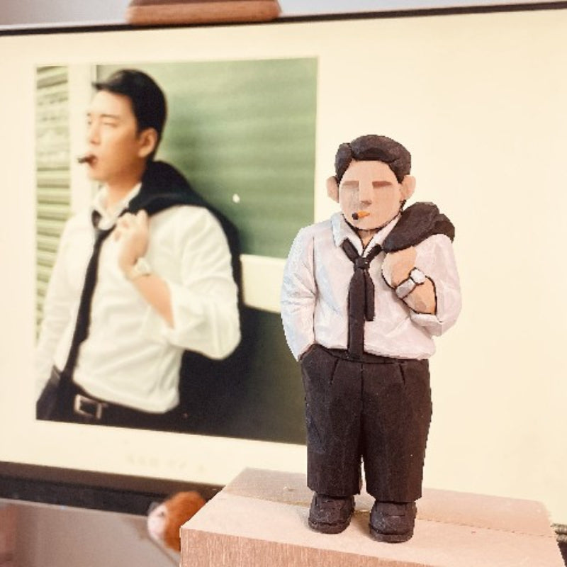 Custom figurine of a man in a white shirt and black tie, holding a coat over his shoulder, hand-carved from wood.