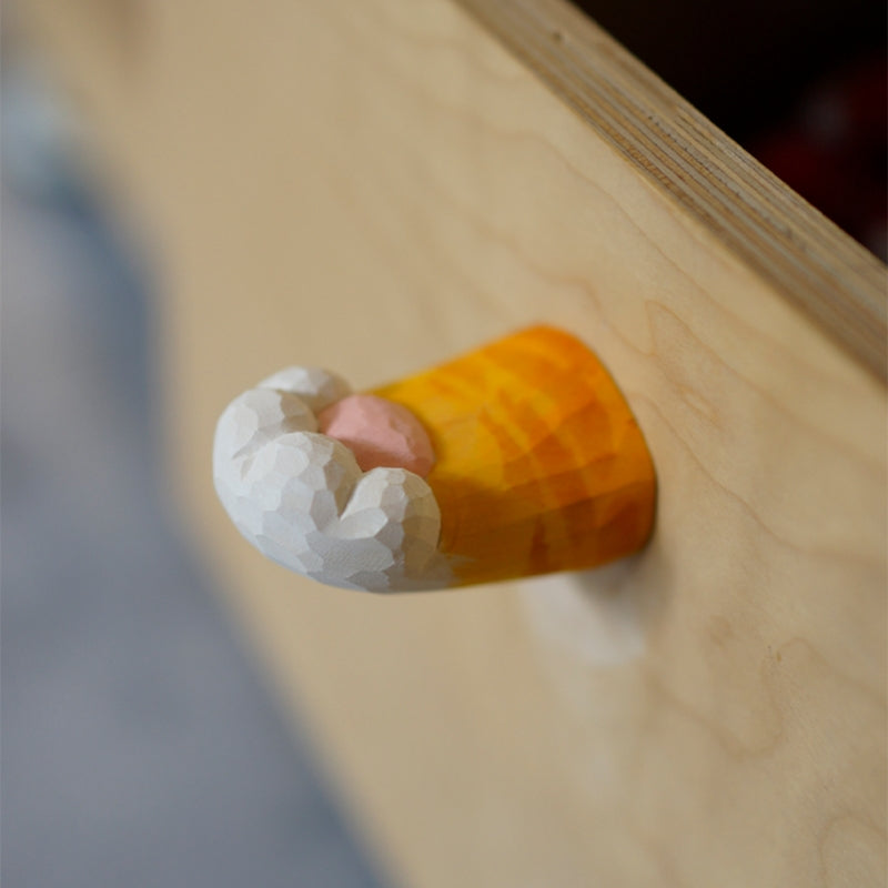 Close-up of a hand-carved wooden cat’s claw handle attached to a drawer, showcasing the detailed craftsmanship.