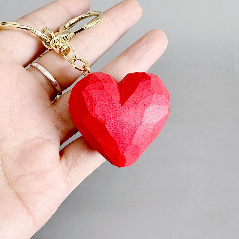 Detailed view of a red heart keychain on a gold ring.