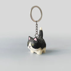 Handmade Holstein cat keychain with black and white stripes, featuring a smiling expression and a metal keyring.