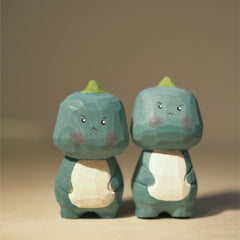 Two adorable light green dinosaur figures, hand carved and painted.