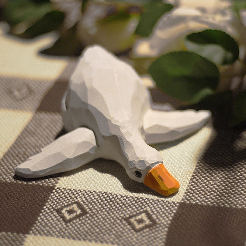 Lying wooden duck figure, handmade as a table decoration.