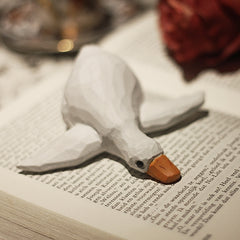 Lying wooden duck figure on a book, hand-painted.