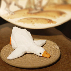 Wooden duck statue placed on a woven mat.