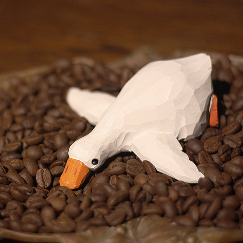 Lying wooden duck figurines in white, hand-painted.