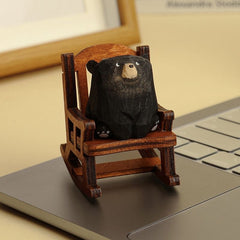 Black bear figurine sitting in a rocking chair.