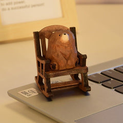 brown bear figurine sitting in a rocking chair.