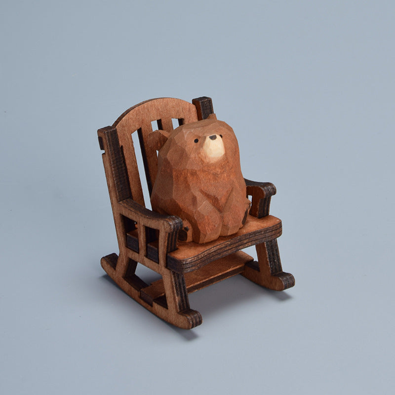 Hand-carved bear figurine sitting in a rocking chair.