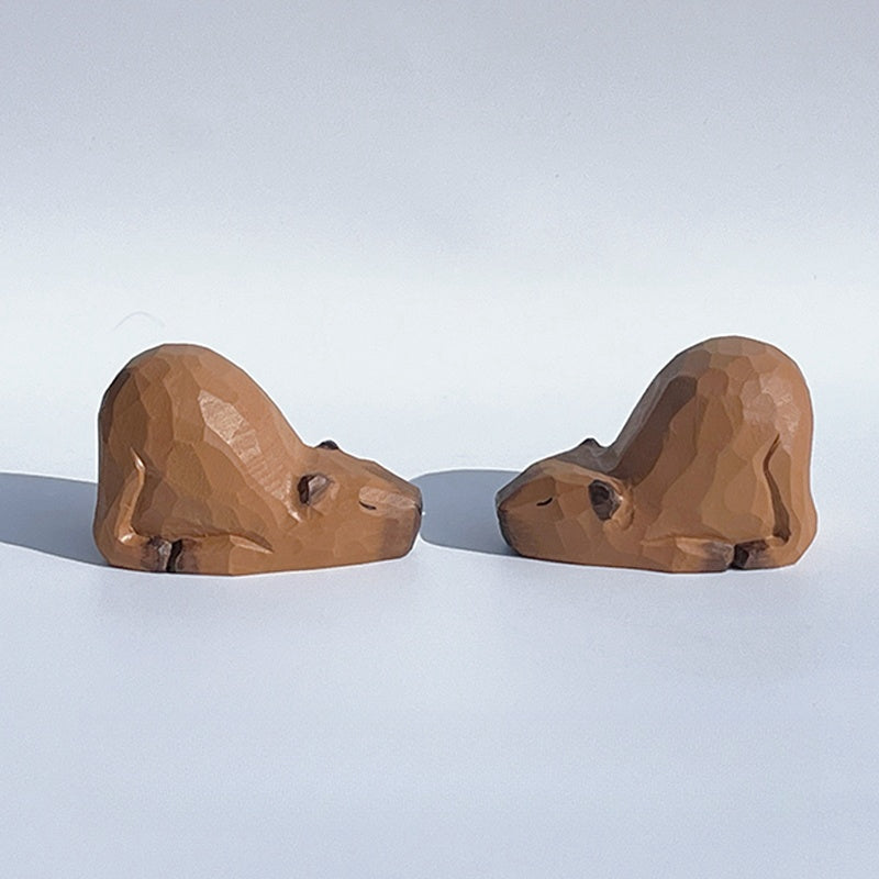 Two capybara figurines, hand-painted wooden statues.