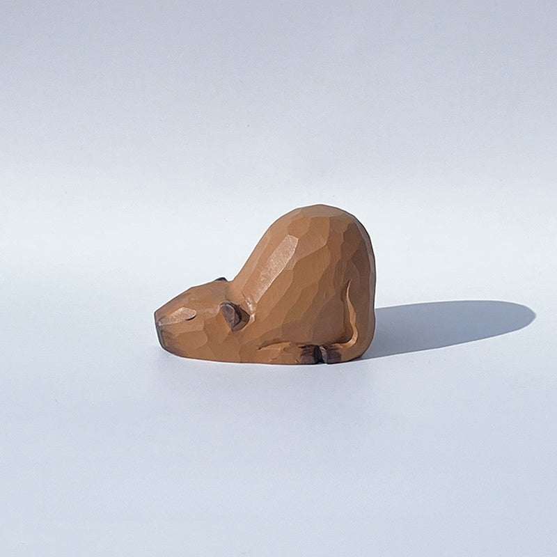 Side view of sleeping capybara figurine