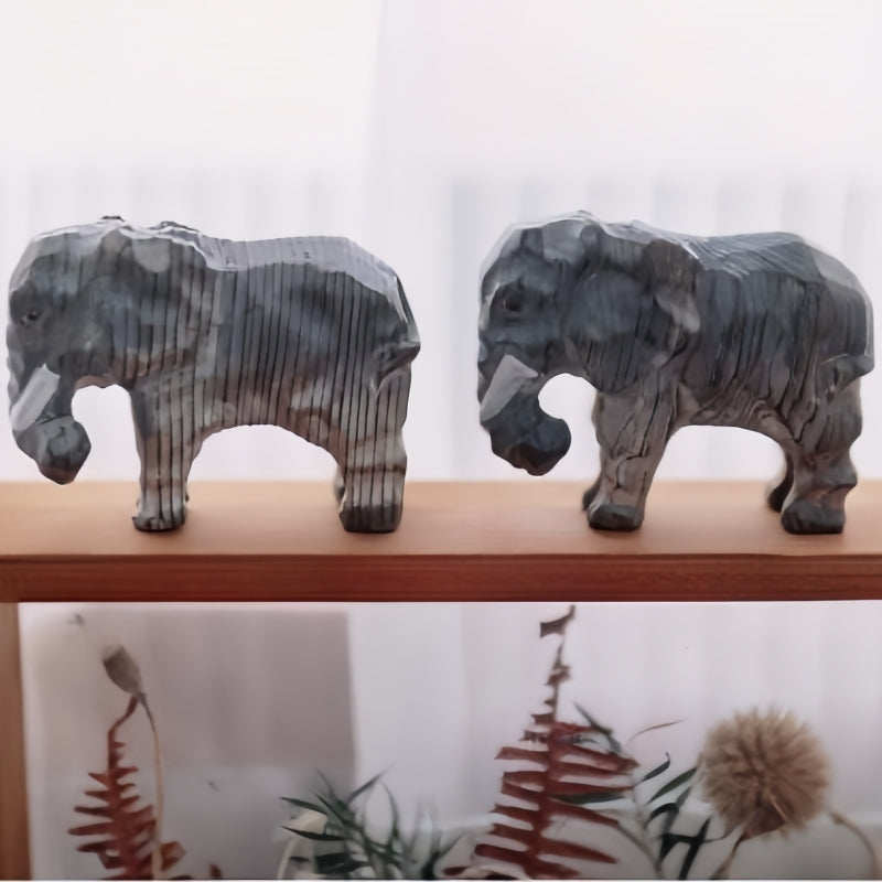 The wood elephant sits on the shelf of the desk.