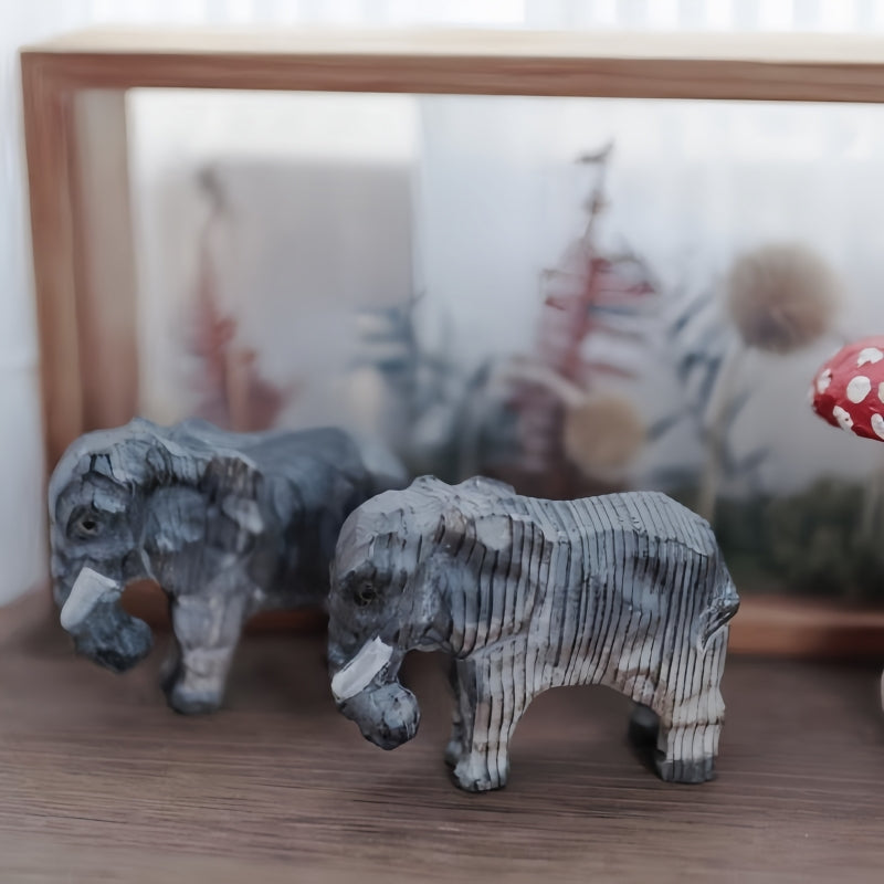 Elephant figurines, hand-carved and painted wooden sculpture with black vertical stripes.