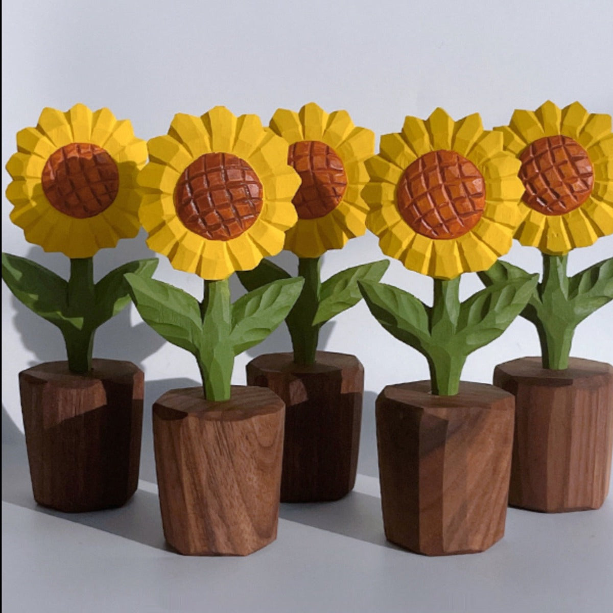 Unique sunflower sculpture carved from wood, displayed against a simple background to highlight its features.